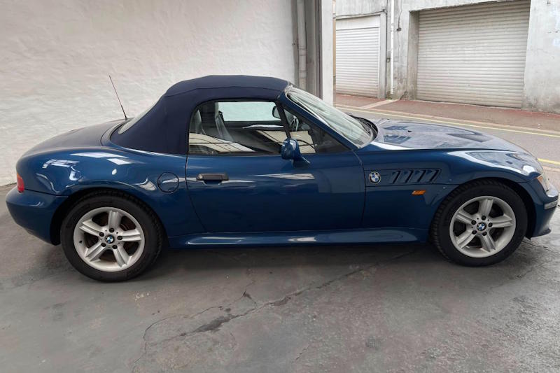 Ford Mustang Trouwauto Zelf Rijden (Klassieke Verhuur) Bruidspaar poseert met een vintage Ford Mustang in een tuin