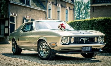 Ford Mustang Trouwauto Zelf Rijden (Klassieke Verhuur) Bloemen op een vintage Ford Mustang voor een kasteel